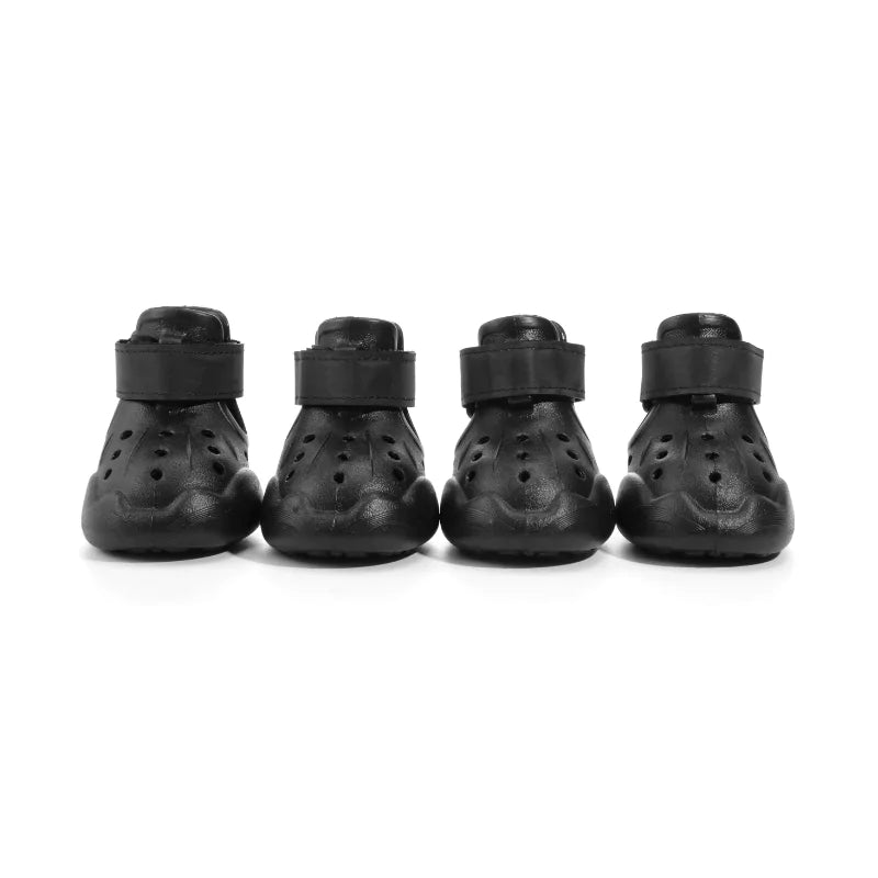 Four black protective dog boots on a white background
