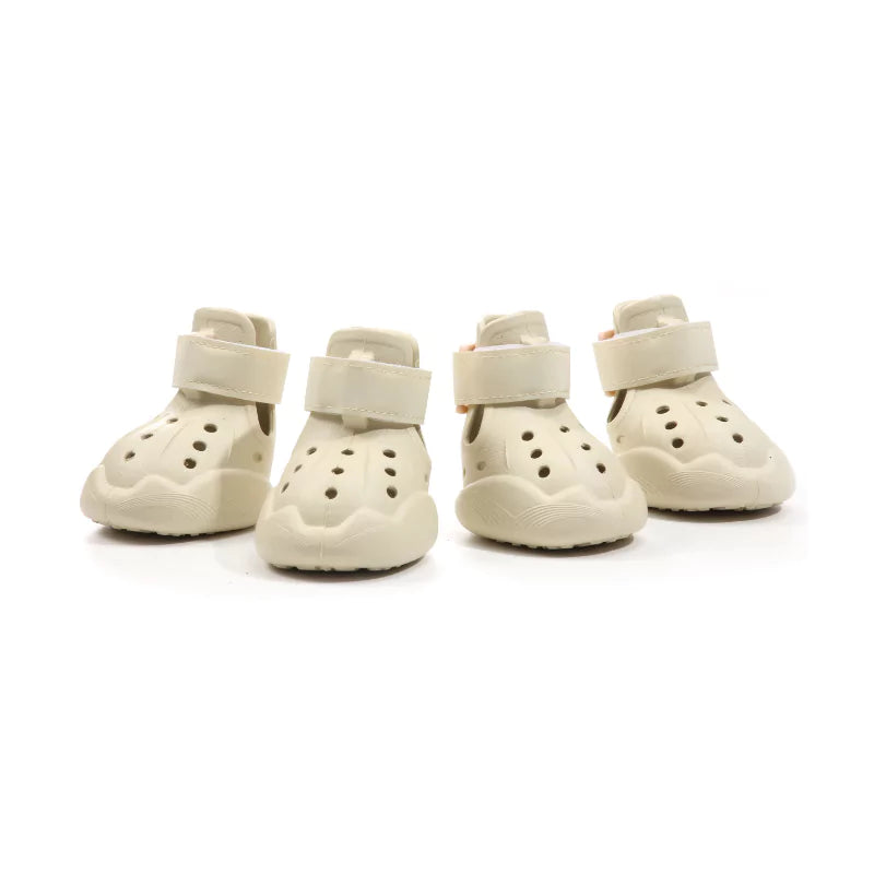 Four pairs of cream-colored dog boots on a white background