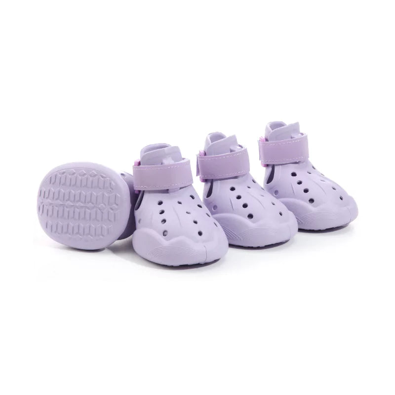 Set of four purple children's shoes with velcro straps on a white background