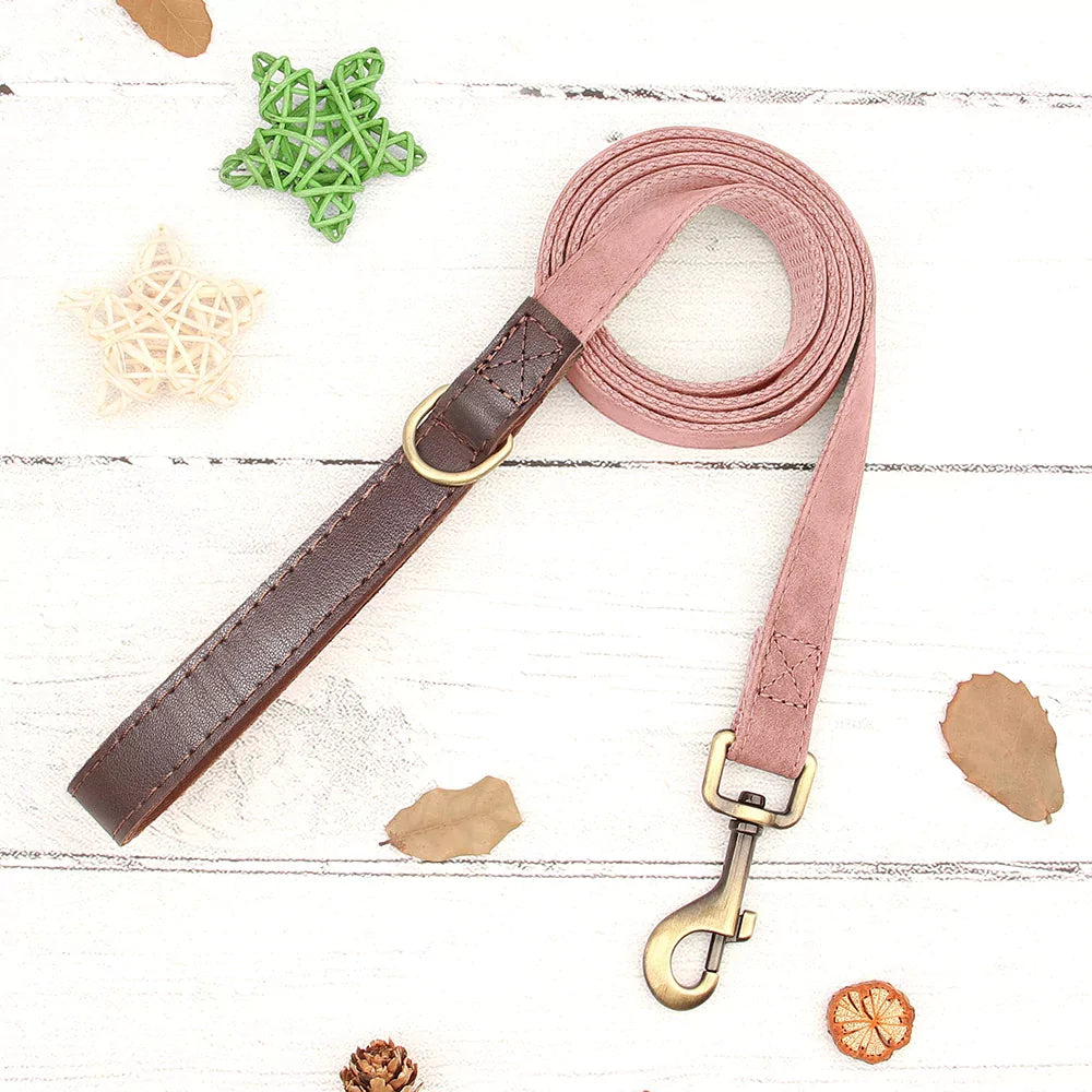 Dog leash with pink and brown design on a white wooden surface with decorative elements.