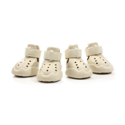 Four pairs of cream-colored dog boots on a white background