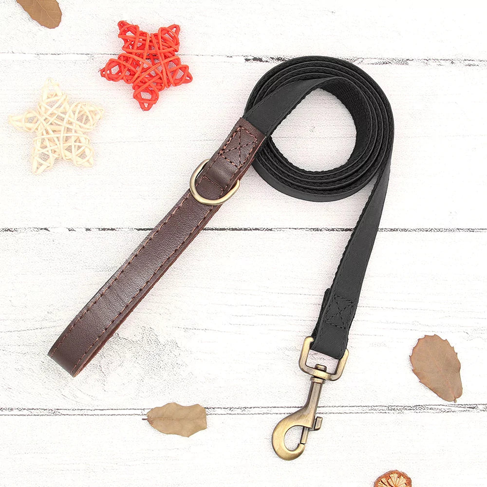 BLACK Dog leash with brown and black sections on a white wooden surface.